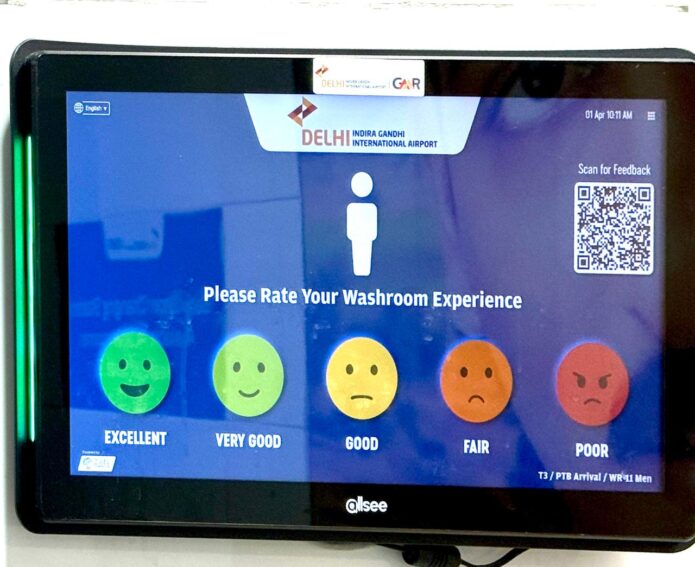 Feedback terminal at Delhi Indira Gandhi International Airport asking passengers to rate their washroom experience on a five-point emoji scale.