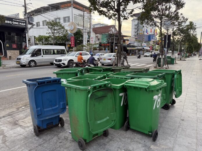 Green municipal waste bins on a street, a quiet reminder of what happens after someone decides to act