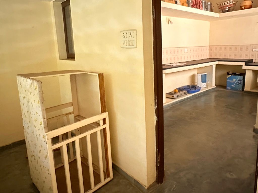 A baby cot in an emptying room during renovation — on letting go of things that hold too much memory