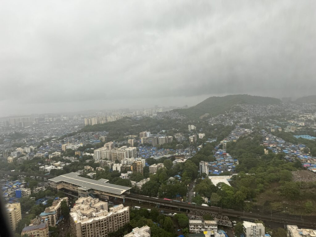 Houses climbing a hillside in Mumbai, seen from a descending plane
